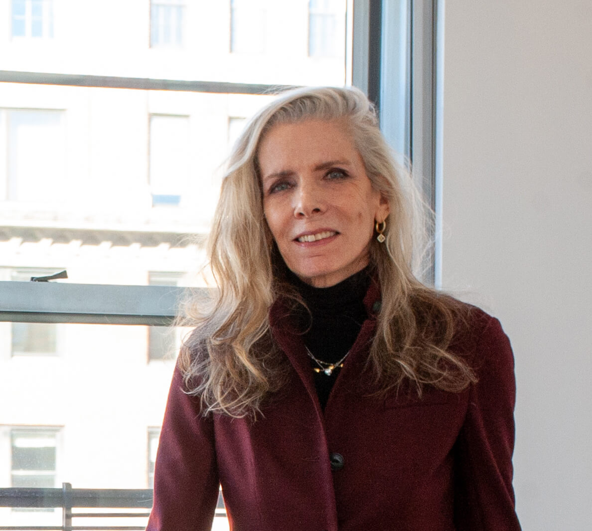 Portrait of Paula McDonald next to her Manhattan office window. She is owner & founder of Paula McDonald Design Build Interiors 