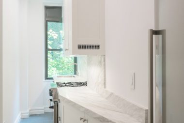 prewar apartment renovation nyc featuring narrow kitchen in white
